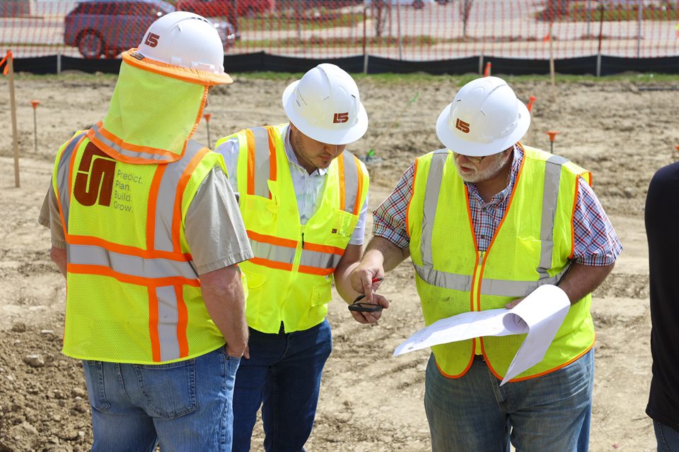 Three construction professionals reviewing plans