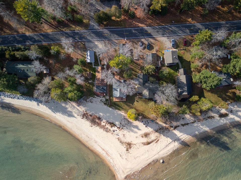 Lakefront home and wooded property seen from above